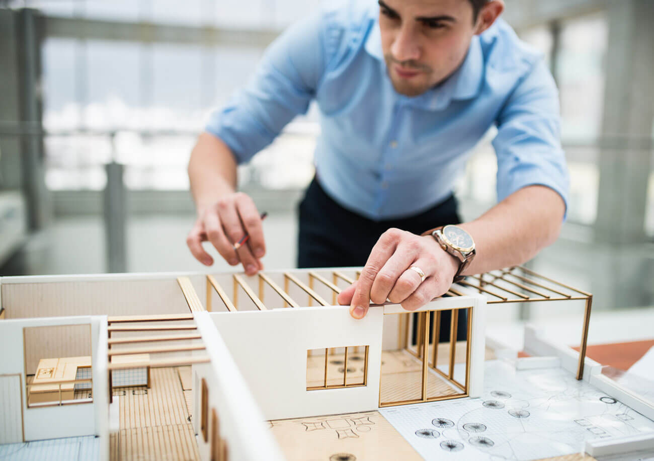 geometra che lavora ad un modellino di abitazione - progettazione sartoriale